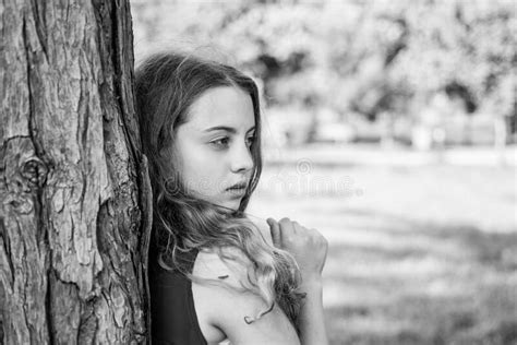 Girl Long Curly Hair Lean On Tree Trunk Lonely Child Stock Photo