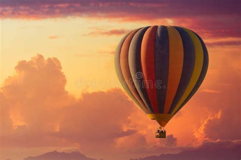 A Hot Air Balloon Rising Under Partly Cloudy Skies During A Brillant