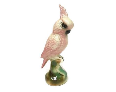 A Pink Bird Sitting On Top Of A Green Vase