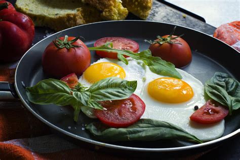 Pan Van Gebraden Eieren Basilicum En Tomaten Met Brood Op Oppervlakte