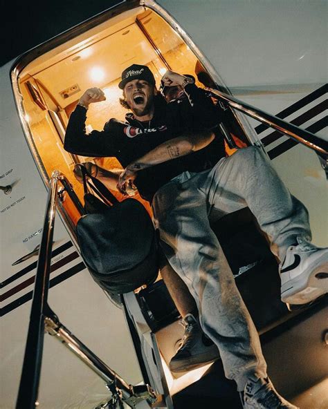 a man sitting on the steps of an airplane with his mouth open and hands in the air