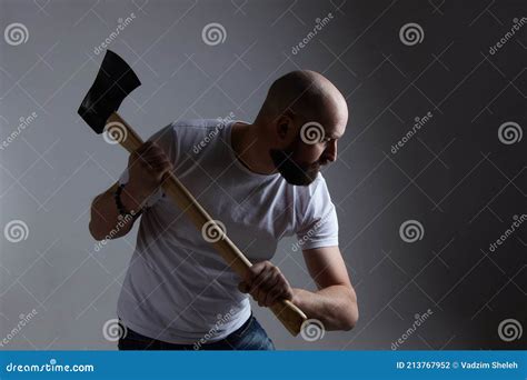 Man Of Caucasian Appearance Makes A Swing With An Axe Photo Shoot In