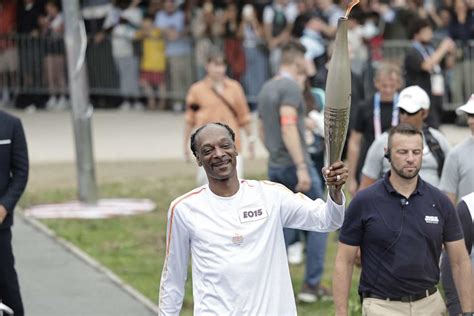 Snoop Dogg Dances the Olympic Torch Through Paris Ahead of Opening Ceremony