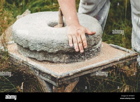 The Ancient Quern Stone Hand Mill With Grain The Man Grinds The Grain