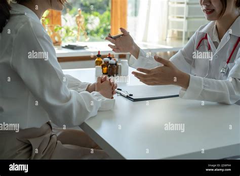 Asian Female Doctor In White Medical Uniform Consult Female Patient In