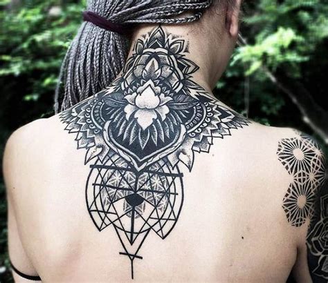 The Back Of A Woman S Neck With An Intricate Tattoo Design On Her Left