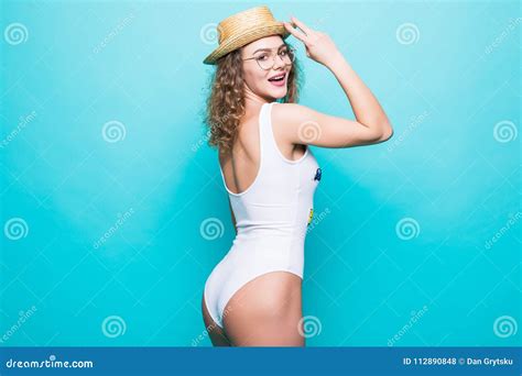 Attractive Girl In A White Bikini Hat Sunglasses On A Bright Blue