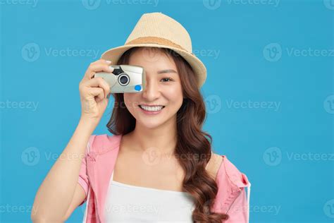 Attractive energetic Asian woman happily holding cemara isolated on