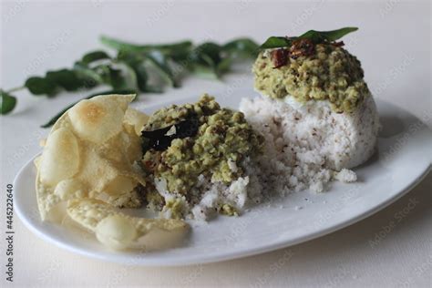 Steamed rice cake served with green gram curry and papad. A favorite dish of Kerala commonly ...