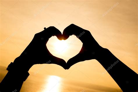 Silhouette hand making heart shape with sunset Stock Photo by ©jethita 77931340