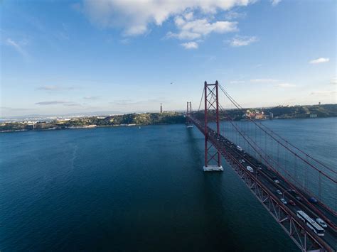 Aerial View Of The Cristo Rei Monument With Ponte 25 De Abril Bridge In