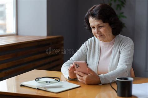 European Middle Aged Senior Woman Holding Using Smartphone Touch Screen