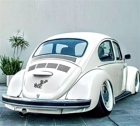 A White Vw Bug Parked In Front Of A Building