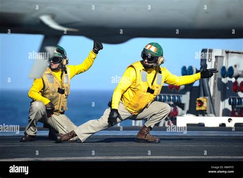 Flight Directors Known As Yellow Shirts Signal An F A Super Hornet