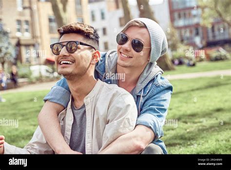 Gay Teenage Couple Sitting Together In Park Stock Photo Alamy