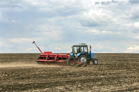 Spring Sowing Work A Tractor With A Seeder Trailer Works In The Field