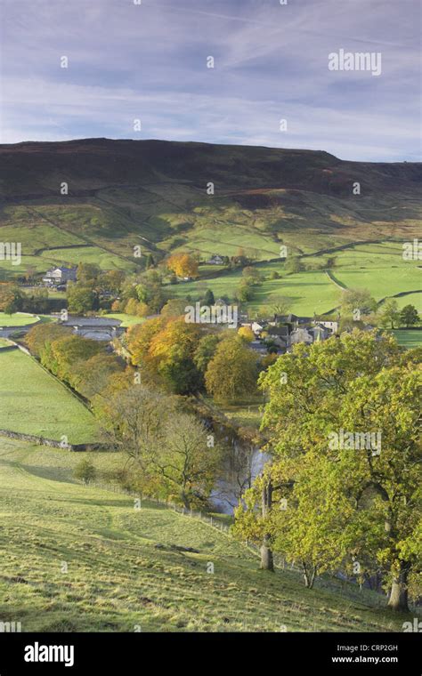 View of pasture, trees, river and village, River Wharfe, Burnsall, Wharfedale, Yorkshire Dales N ...