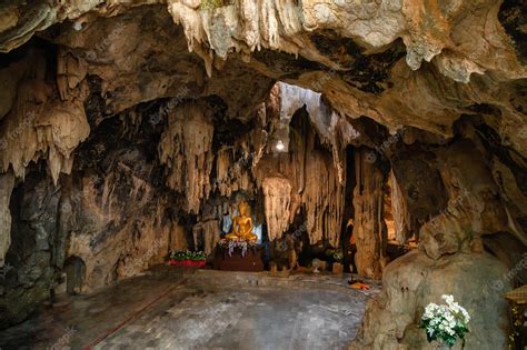 Premium Photo | Stalactite limestone cave with buddha statue