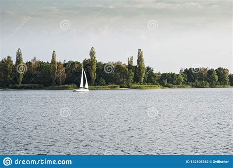 Sailing Boat On A Calm Lake With Reflection In The Water Serene Scene