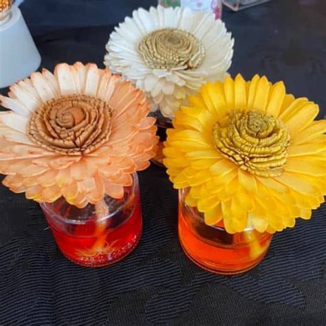 Three Vases With Flowers In Them Sitting On A Table