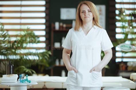 Female Medical Massage Therapist In Spa Salon Looking At Camera Stock