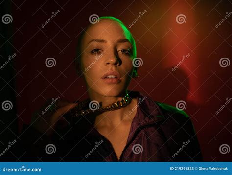 Woman Standing At The Dim Light And Posing To The Camera While Holding Her Chain Stock Image