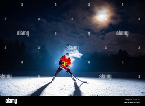 Hockey Photo Player Strike The Puck On The Ice In The Night Under The