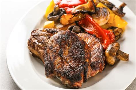 Premium Photo Plate With Tasty Grilled Steaks And Vegetables Close Up