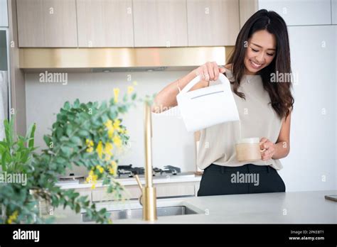 Woman Pouring Hot Water Into A Cup In The Kitchen Stock Photo Alamy