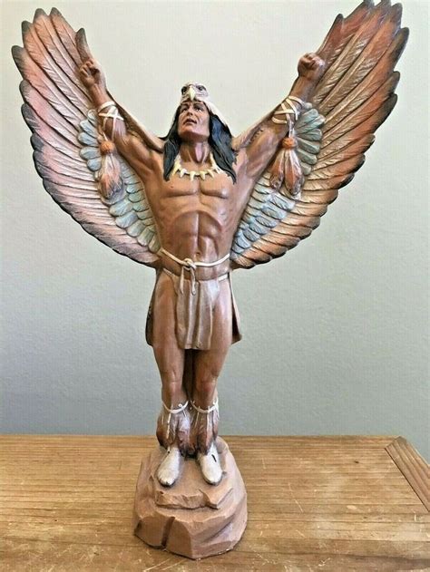 A Statue Of A Man With Wings On Top Of A Table