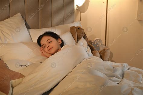 Little girl sleeping in bedroom lit by night lamp: Stock Photo | Download on Africa Images 733403