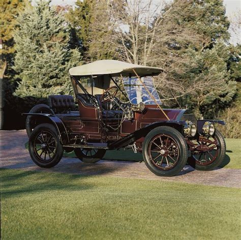 An Old Model T Car Parked On The Side Of A Road In Front Of Some Trees