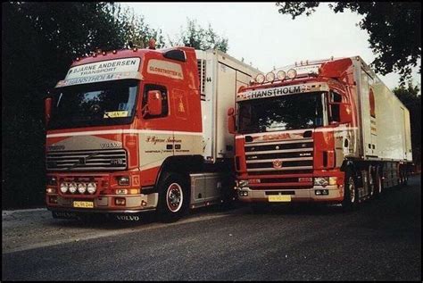 Two Red And White Trucks Are Parked On The Side Of The Road Next To