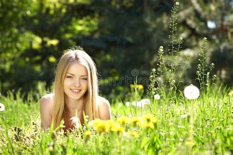 Fille De Ressort Se Trouvant Sur Le Champ Des Pissenlits Photo Stock