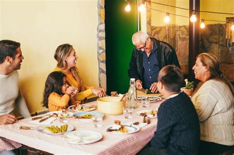 Feliz familia latina cocinando juntos durante la cena en casa Centrándose en la cara del abuelo