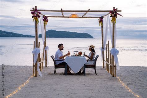 Romantic dinner on the beach, couple man and woman mid age having a ...