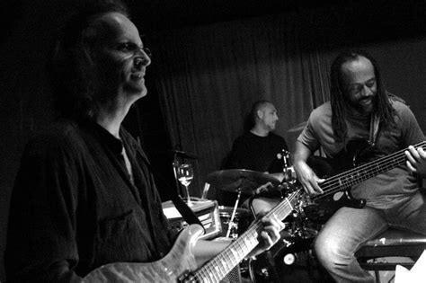 two men are playing guitars in a black and white photo