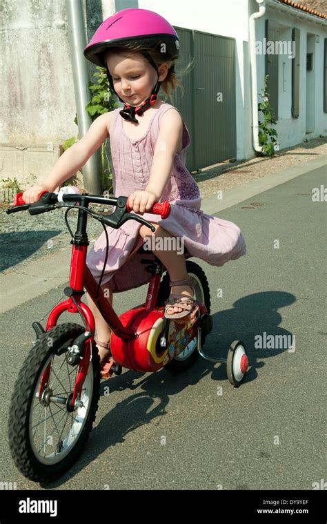 Girl Riding Bicycle With Training Wheels Stock Photo Alamy