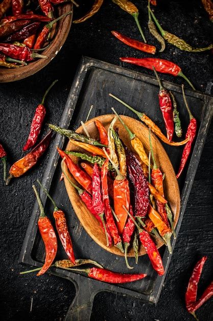 Premium Photo | Multicolored pods of dried chili peppers on a cutting board