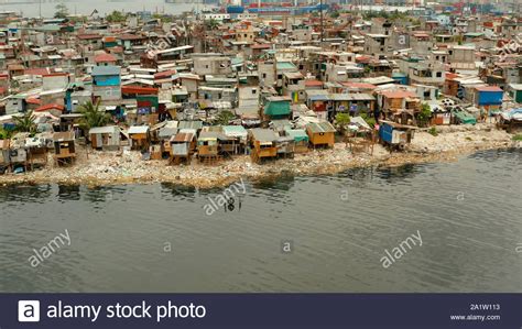 Slums in Manila near the port. River polluted with plastic and garbage ...