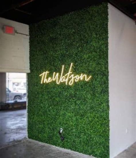 an artificial wall with the word hudson written on it and grass growing ...