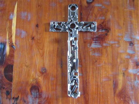 A Metal Cross Sitting On Top Of A Wooden Table