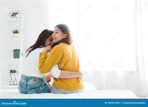 Back View Of Women Lesbian Happy Couple Waking Up In Morning Sitting On Bed Stretching In Cozy