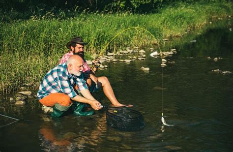 Premium Photo Two Men Friends Fisherman Fishing On River Old Father