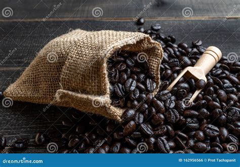 Closeup Fresh Coffee Beans In Bag Made From Burlap On Wooden Surface