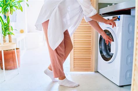 Mujer Que Usa Una Lavadora Moderna Para Lavar La Ropa En Casa Foto