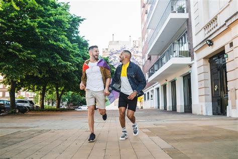 Retrato De Joven Pareja Gay Cogidos De La Mano Y Corriendo Junto Con La