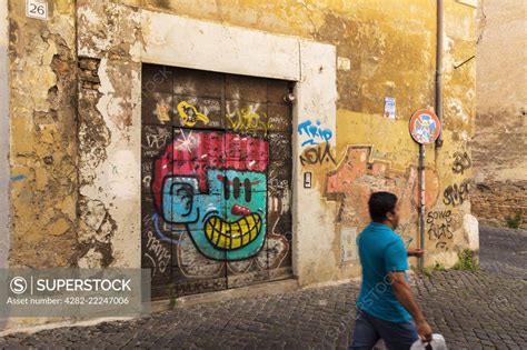 Colourful street art adorns the backstreet walls of Trastevere. - SuperStock