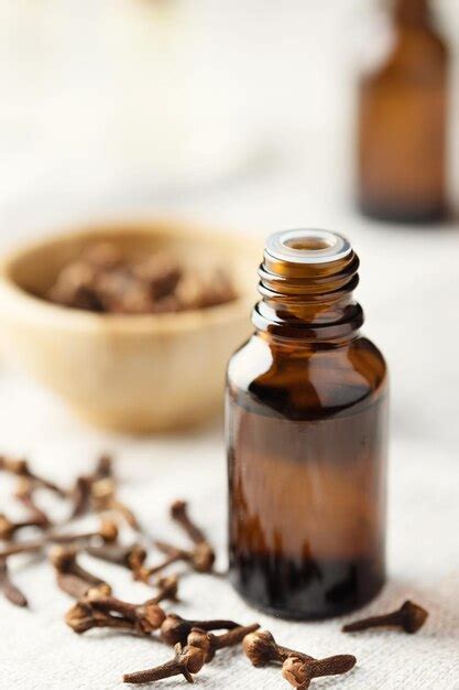 Premium Photo | A glass bottle of clove oil and a clove on the table essential oil of cloves