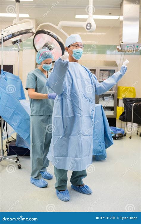 Nurse Assisting Surgeon With Sterile Gown Stock Image Image Of Room